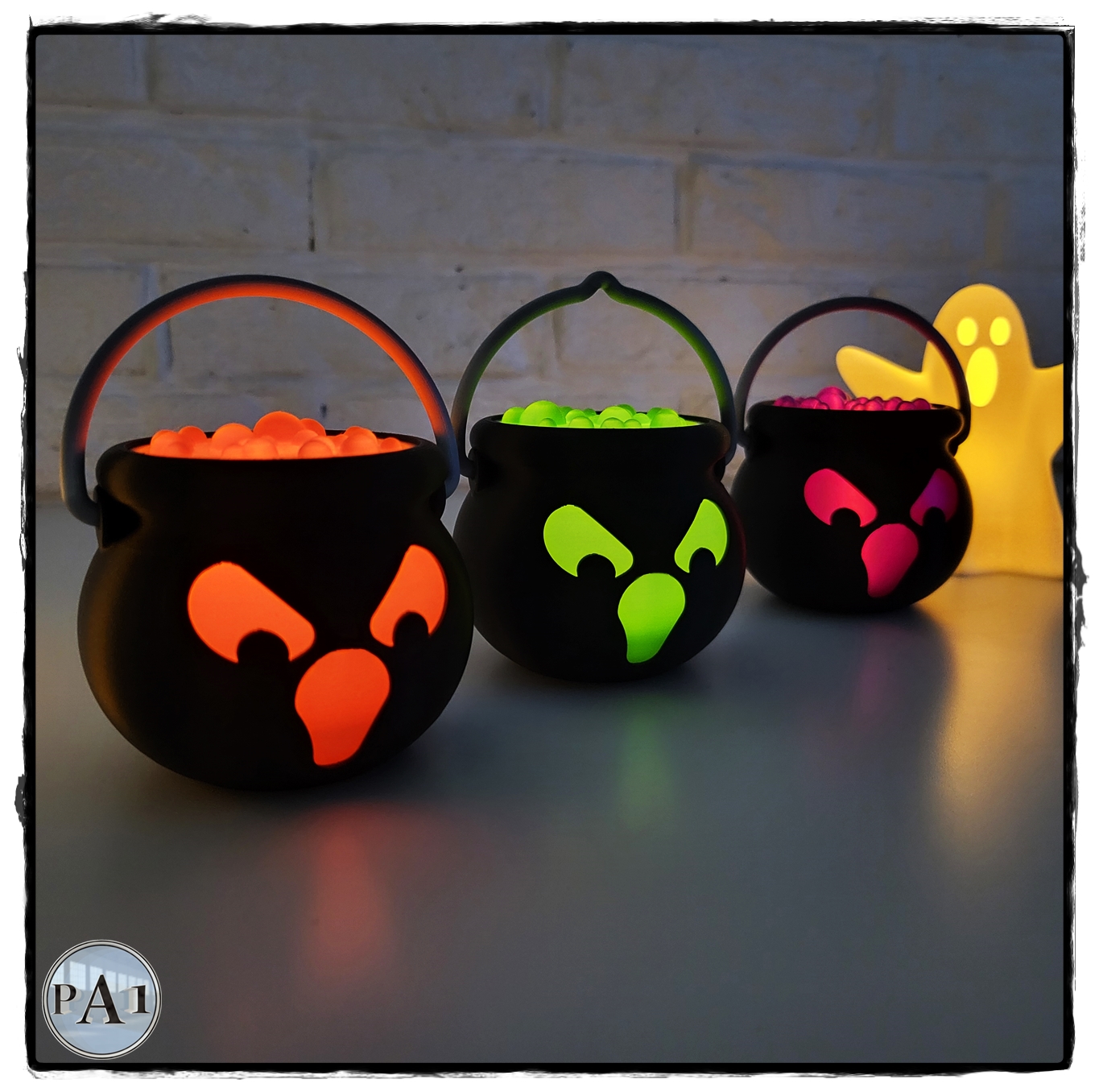 Tealight Spooky Cauldrons glowing orange, green and pink with LED tealights